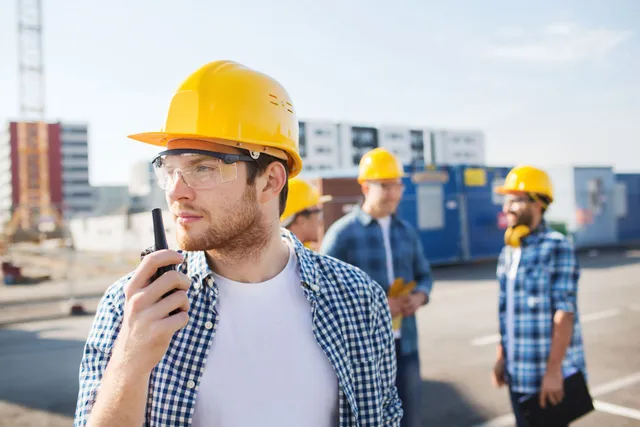 Construction workers in safety helmets at a worksite.