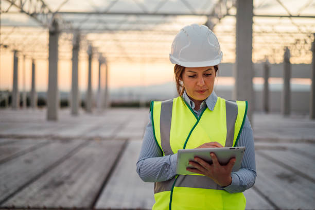Female construction engineer is using digital tablet on the construction site.